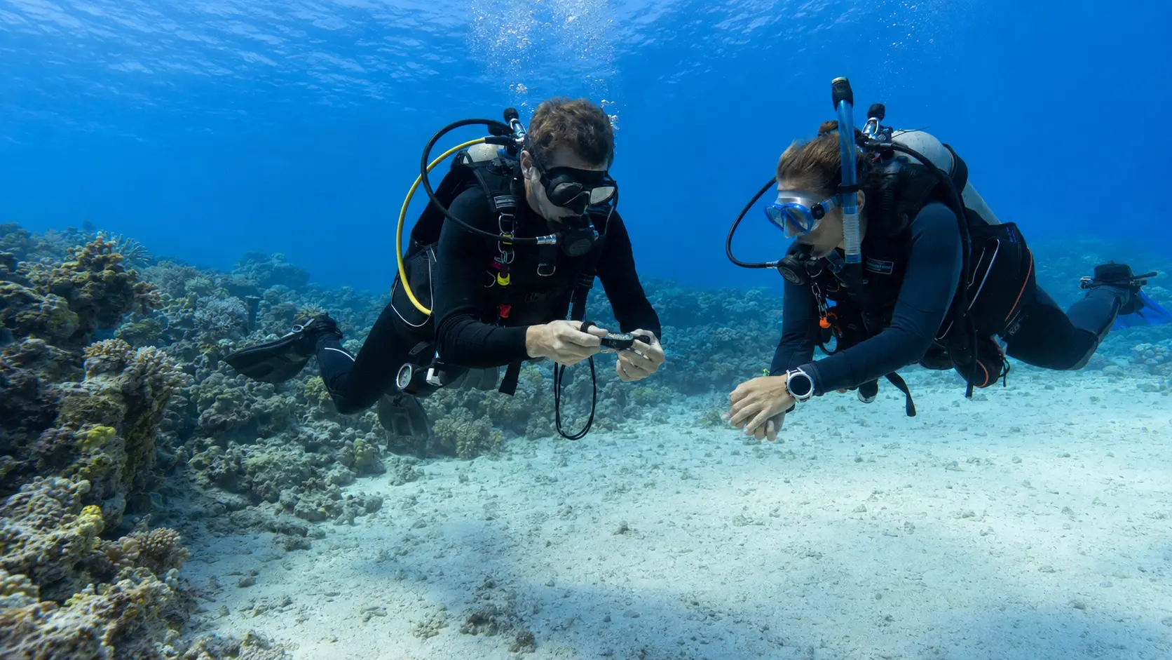 Instructor teaching underwater compass navigation during an advanced diving course in Hurghada